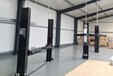 Elektroinstallation in einer Autowerkstatt mit Hebebühnen, Kabeltrassen und vorbereiteten Anschlussleitungen.